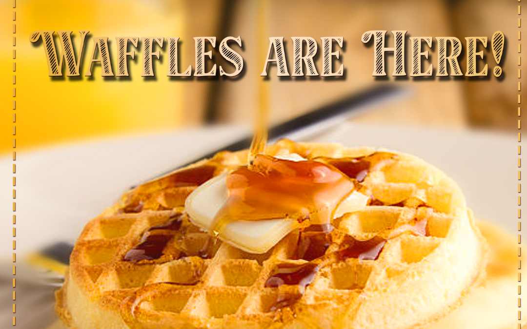 Waffle with a slice of butter while maple syrup is dripping on top.