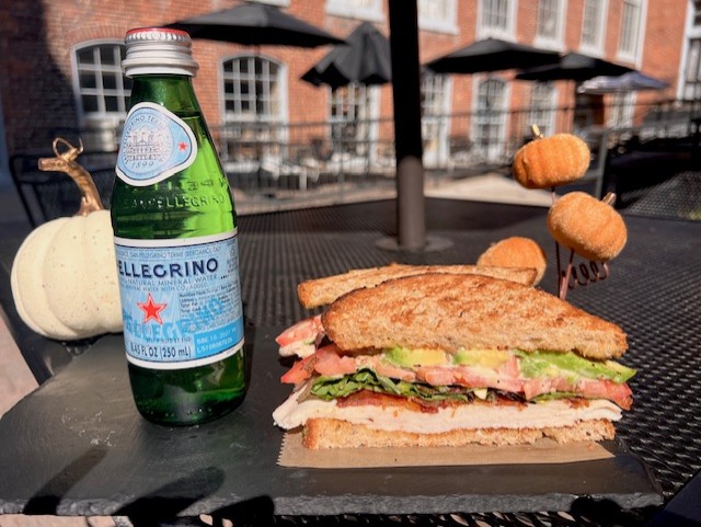 A sandwich with pellergino drink on the side.